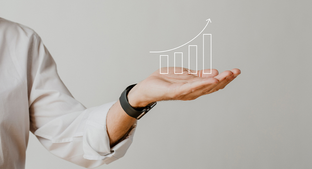 Person holding a hand-drawn rising bar chart, symbolizing business growth, success, and financial progress